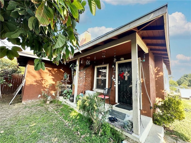 entrance to property with a lawn