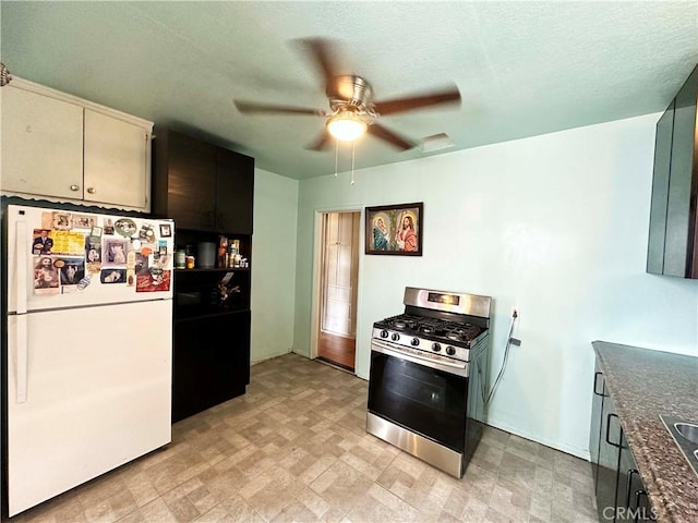 kitchen featuring gas stove, white fridge, sink, and ceiling fan