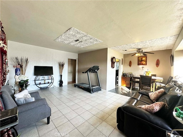 tiled living room with ceiling fan and a textured ceiling