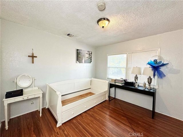 bedroom featuring dark wood-type flooring and a textured ceiling