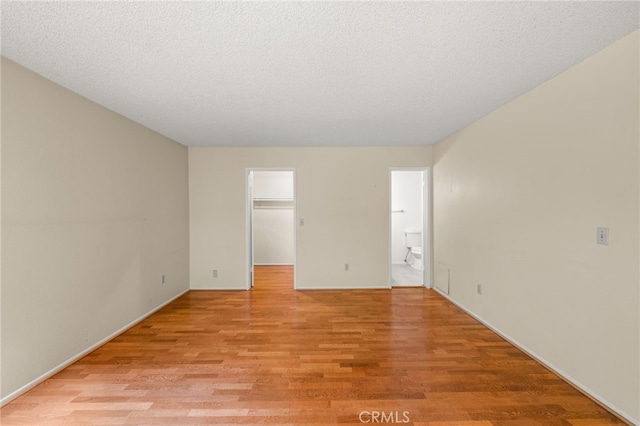 unfurnished room featuring light hardwood / wood-style floors and a textured ceiling