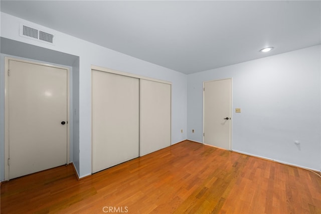 unfurnished bedroom with hardwood / wood-style flooring and a closet