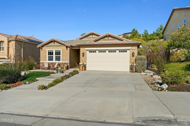 view of front of home with concrete driveway, an attached garage, stone siding, and stucco siding