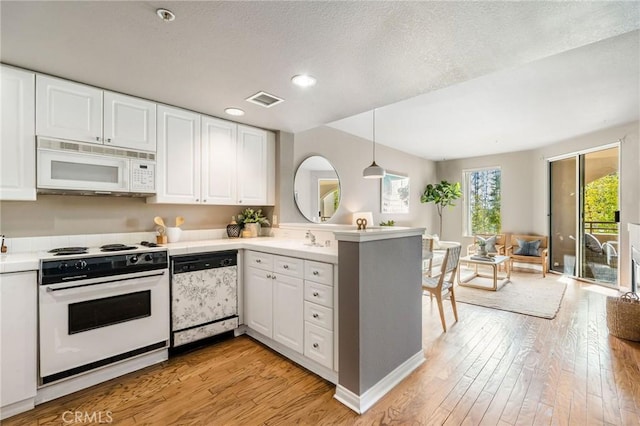 kitchen with light countertops, white appliances, and white cabinetry