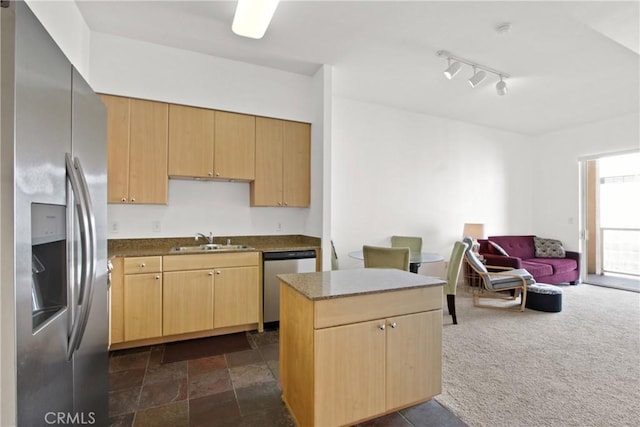 kitchen with light brown cabinetry, sink, dark carpet, and stainless steel appliances