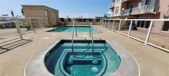 view of pool with a hot tub and a patio area