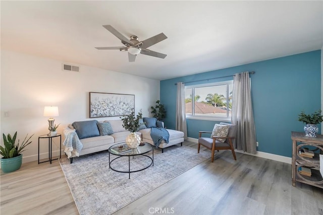 living room with light hardwood / wood-style flooring and ceiling fan