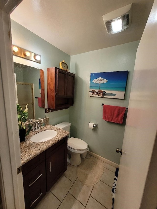 bathroom with vanity, walk in shower, tile patterned floors, and toilet