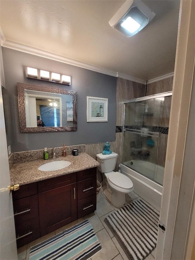 full bathroom with combined bath / shower with glass door, tile walls, vanity, toilet, and crown molding