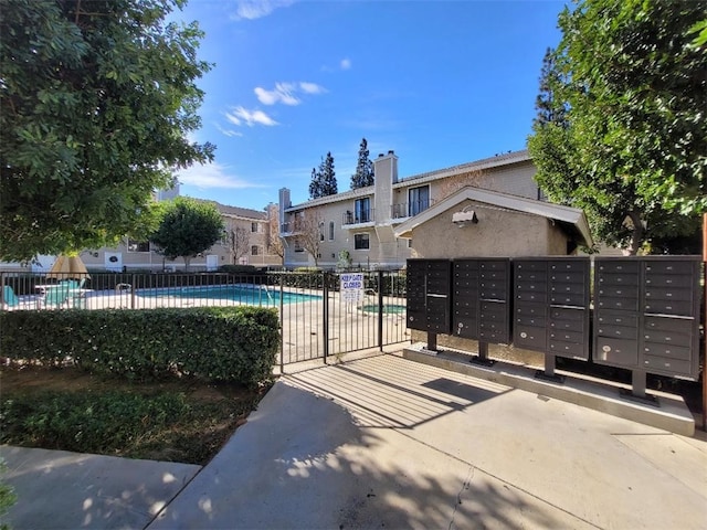 view of home's community with a pool and a mail area