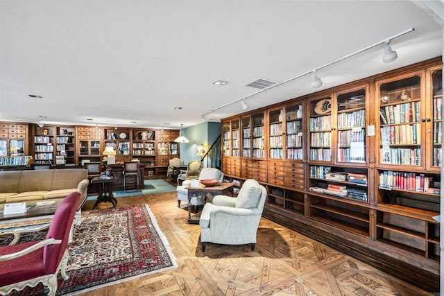 sitting room featuring built in shelves and parquet flooring