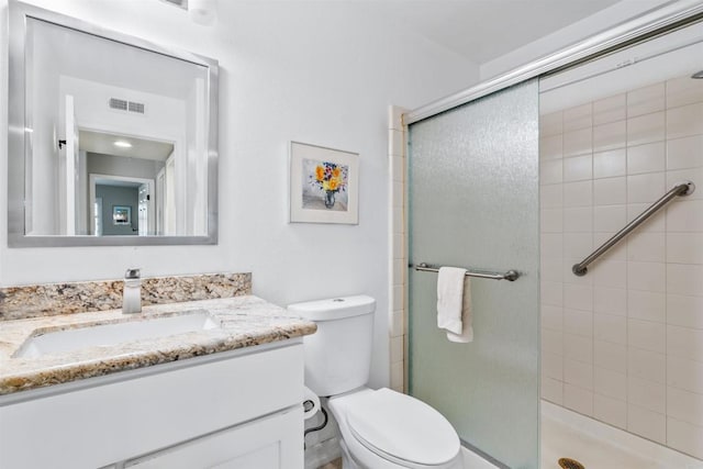 bathroom featuring vanity, an enclosed shower, and toilet