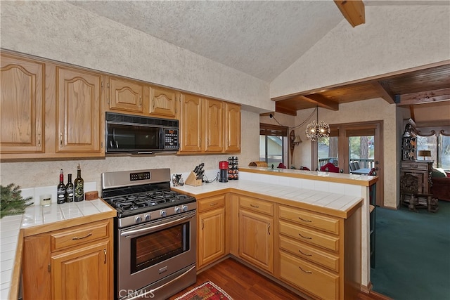 kitchen featuring pendant lighting, tile countertops, lofted ceiling with beams, kitchen peninsula, and gas stove