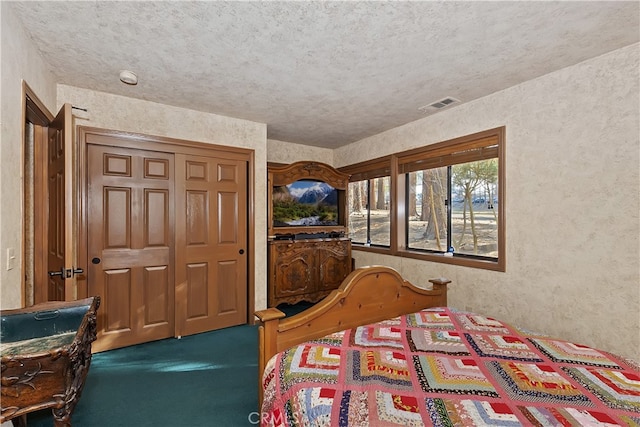 bedroom with a closet, carpet flooring, and a textured ceiling