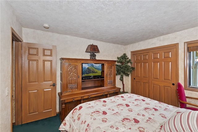 carpeted bedroom featuring a closet and a textured ceiling