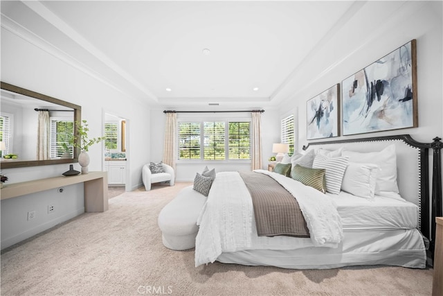 bedroom featuring ornamental molding, a tray ceiling, and light carpet