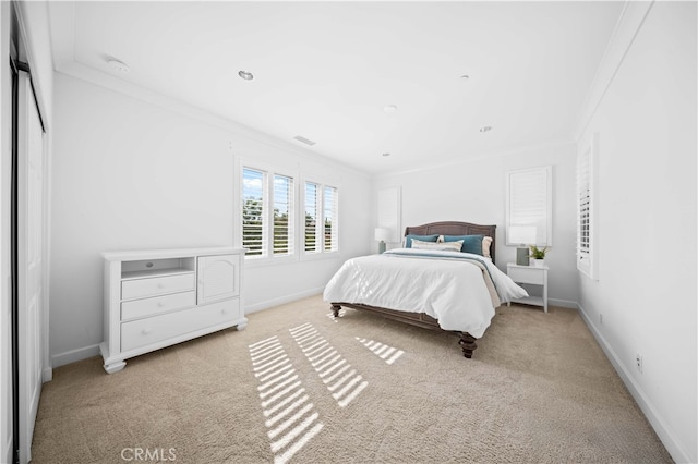 bedroom with crown molding and light colored carpet