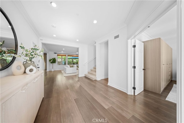 hallway featuring ornamental molding and wood-type flooring