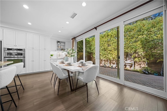 dining space with crown molding and dark hardwood / wood-style floors