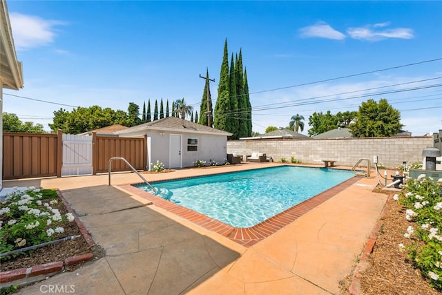 view of pool with an outbuilding, a patio area, and a diving board