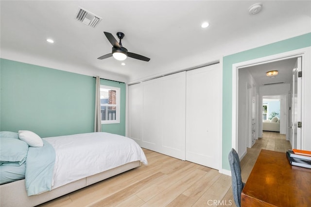 bedroom with a closet, ceiling fan, and light wood-type flooring