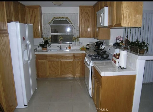 kitchen featuring sink, white appliances, and light tile patterned floors