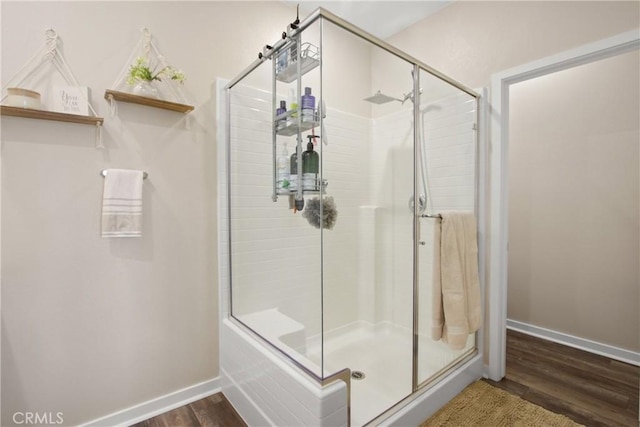 bathroom with an enclosed shower and hardwood / wood-style flooring