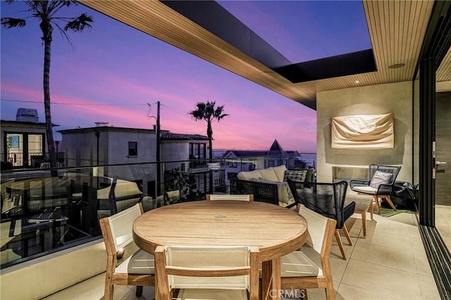 patio terrace at dusk featuring a balcony