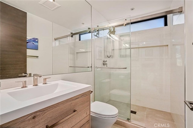 bathroom with a shower with door, vanity, and toilet