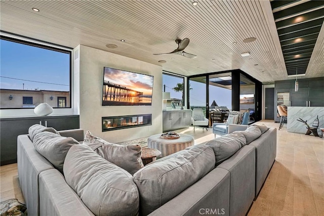 home theater featuring ceiling fan, wooden ceiling, and light hardwood / wood-style floors