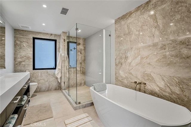 full bathroom featuring tile walls, vanity, tile patterned floors, independent shower and bath, and toilet