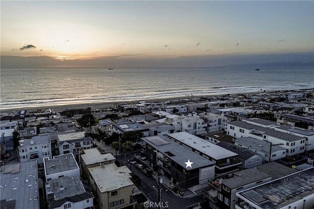 aerial view at dusk featuring a water view