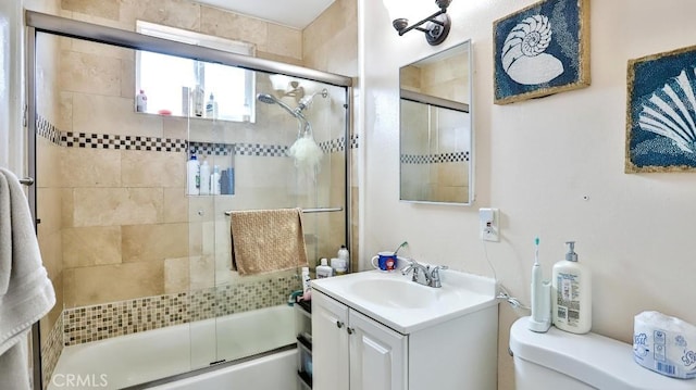 full bathroom with vanity, toilet, and combined bath / shower with glass door