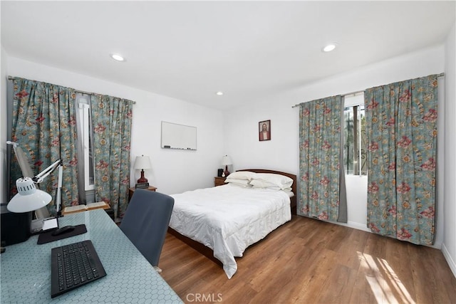 bedroom featuring baseboards, wood finished floors, and recessed lighting