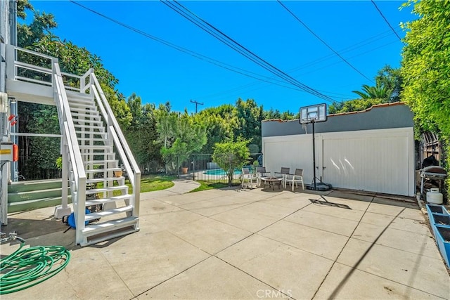 view of patio / terrace featuring stairway, fence, and a fenced in pool