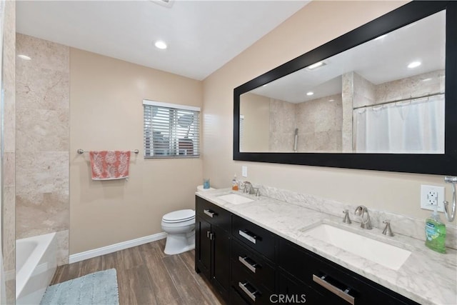 bathroom featuring baseboards, wood finished floors, a sink, and a shower with shower curtain