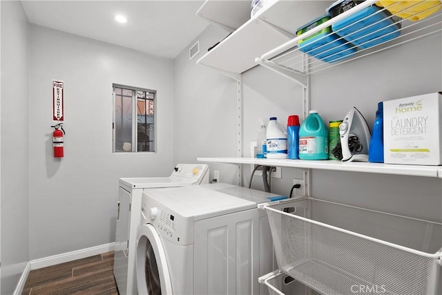 washroom featuring laundry area, dark wood-style flooring, visible vents, baseboards, and washer and dryer