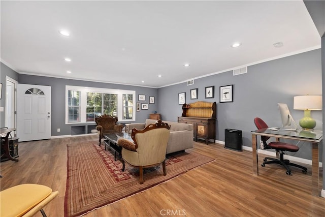 living room with visible vents, crown molding, baseboards, and wood finished floors