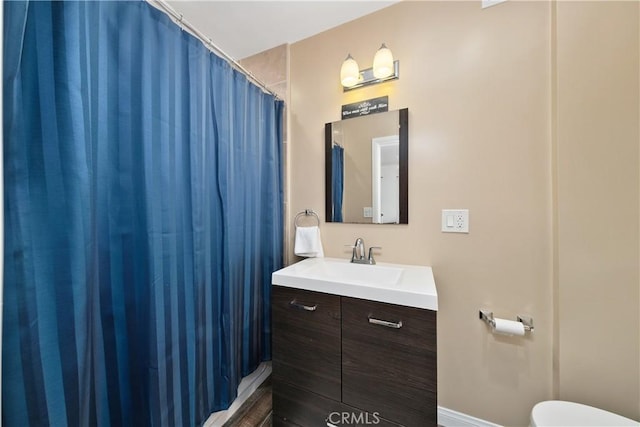 full bath featuring a shower with curtain, vanity, and toilet