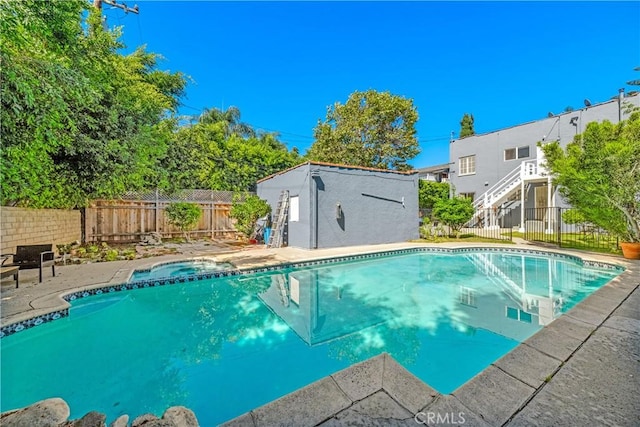 view of pool featuring an outbuilding, a patio, a fenced backyard, an in ground hot tub, and a fenced in pool