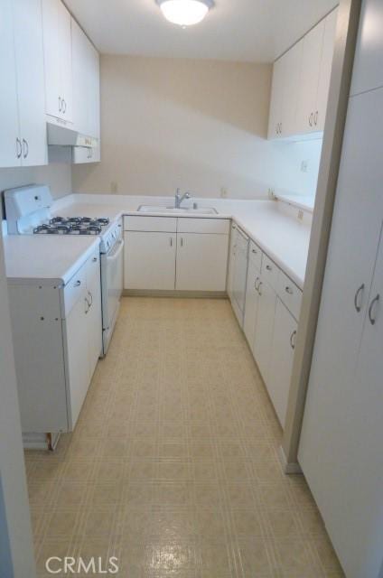 kitchen with sink, gas range gas stove, and white cabinets