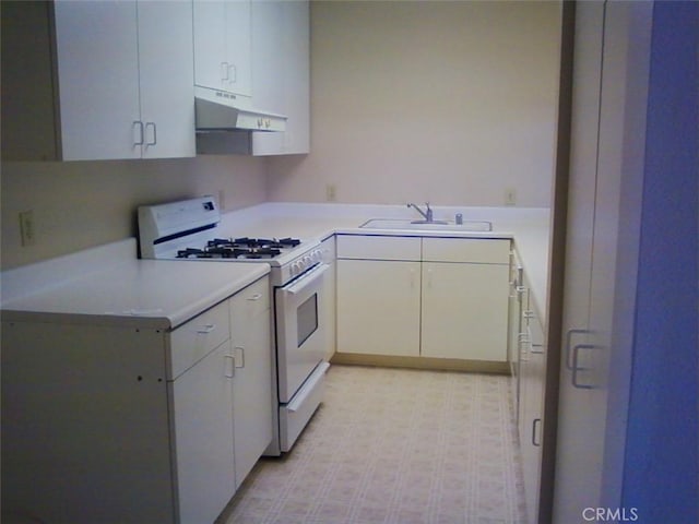 kitchen featuring white cabinetry, sink, and white gas stove