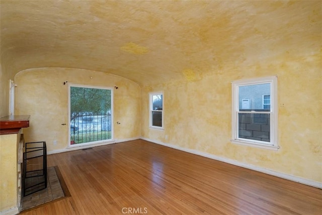 unfurnished living room with lofted ceiling and hardwood / wood-style flooring