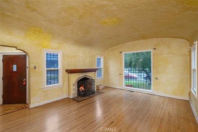 unfurnished living room featuring lofted ceiling and hardwood / wood-style floors