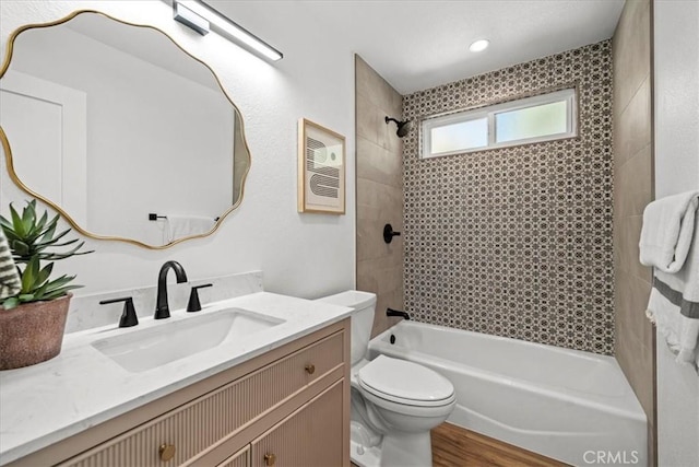 full bathroom with vanity, toilet, tiled shower / bath combo, and wood-type flooring