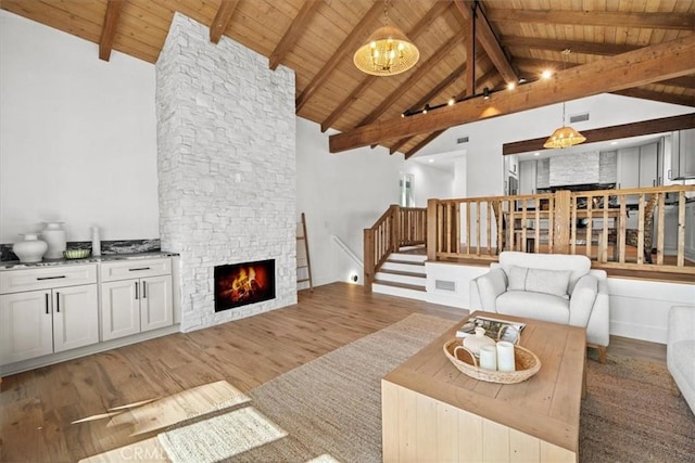 living room featuring wood ceiling, a fireplace, hardwood / wood-style floors, and a notable chandelier