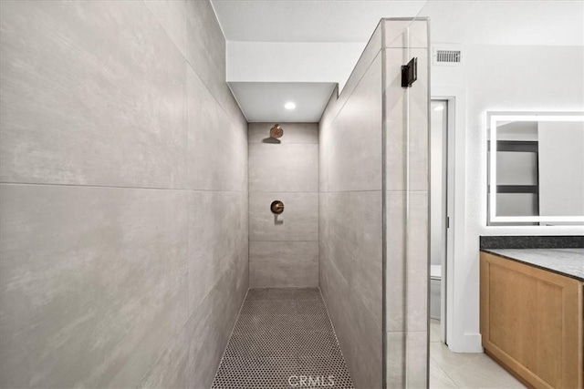 bathroom with vanity and a tile shower