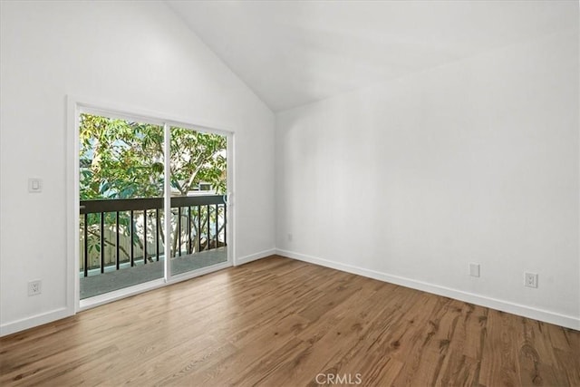 spare room with hardwood / wood-style flooring and high vaulted ceiling