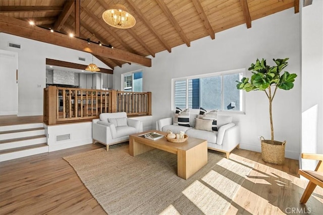 living area with wood ceiling, wood-type flooring, beam ceiling, and a chandelier