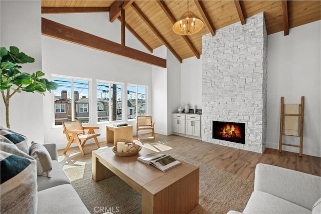 living room featuring wood ceiling, a fireplace, a chandelier, and light hardwood / wood-style flooring